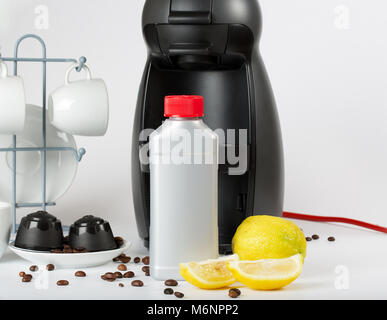 Coffee machine liquid limescale remover. Coffee capsules and coffee machine in the background. Closeup Stock Photo