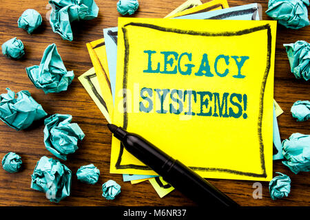 Handwritten text showing Legacy Systems. Business concept for Upgrade SOA Application Written on sticky note paper, wooden background marker folded ye Stock Photo