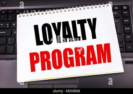 Handwritten text showing Loyalty Program. Business concept writing for Marketing Concept written on notepad note paper the black keyboard background. Stock Photo