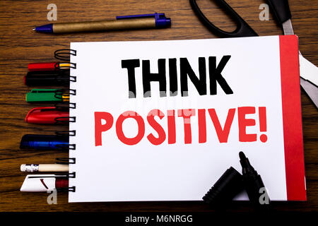 Handwritten text showing Think Positive. Business concept for Positivity Attitude Written on notebook, wooden background office equipment like pens sc Stock Photo