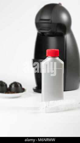 Coffee machine liquid limescale remover. Coffee capsules and coffee machine in the background. Closeup Stock Photo