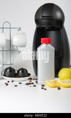 Coffee machine liquid limescale remover. Coffee capsules and coffee machine in the background. Closeup Stock Photo