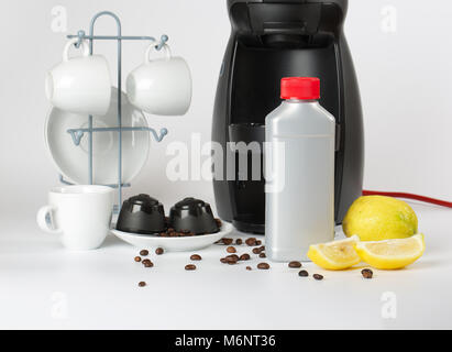 Coffee machine liquid limescale remover. Coffee capsules and coffee machine in the background. Closeup Stock Photo