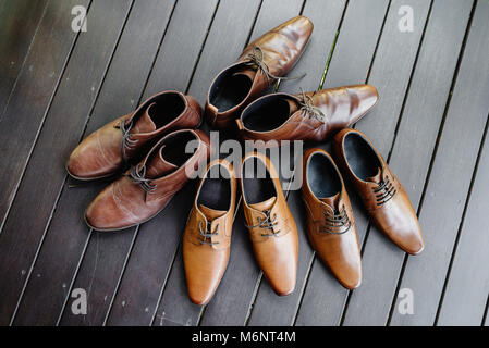 The brown shoes of the groom and the best man during getting ready on the black wooden floor Stock Photo