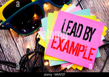 Word, writing Lead By Example. Business concept for Motivation Inspiration written on old wood wooden background with sunglasses Stock Photo
