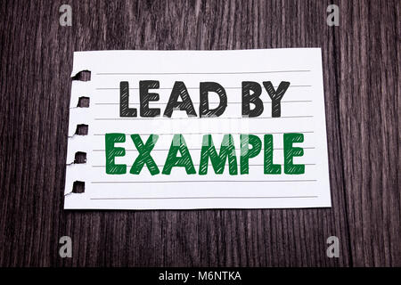Word, writing Lead By Example. Business concept for Motivation Inspiration written on sticky note paper on dark wooden background. Black and green. Stock Photo