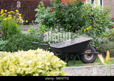 Wheelbarrow in a garden Stock Photo