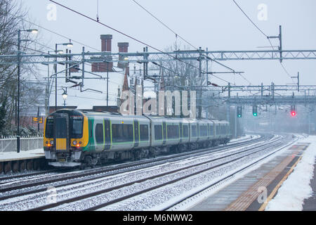 A south bound West Midlands Railway train departing Atherstone train Station covered in snow Stock Photo