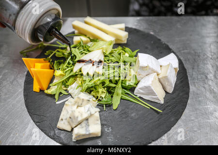The chef prepares the meal. Pour sauce and decorate the dish. Stock Photo