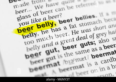 Highlighted English word 'beer belly' and its definition in the dictionary. Stock Photo