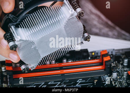 Technician hands installing CPU cooler fan on a computer pc motherboard Bitcoin mining cryptocurrency with GPU rigs. Bitcoins. Stock Photo