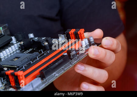 The engineer installing Memory RAM on Motherboard Computer in computer lab. Installing computer ram to motherboard Stock Photo