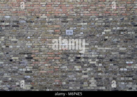Brickwall background with T shape variance in brick type and small vent in middle, West London Stock Photo