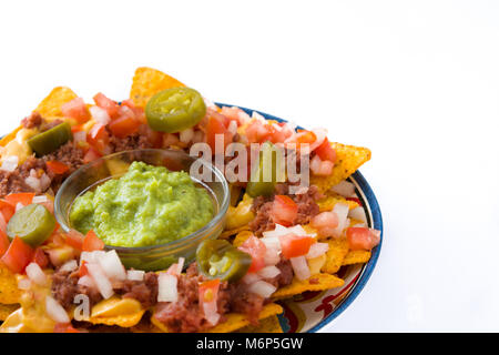 Mexican nachos with beef, guacamole, cheese sauce, peppers, tomato and onion in plate isolated Stock Photo