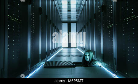 Hooded Hacker in a Mask Watching From Under Floor Hatch in Data Center with Rows of Rack Servers. Stock Photo