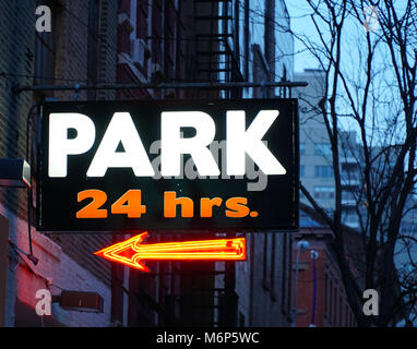 24 hour parking garage sign in neon colors in Manhattan village New York City. Expensive rates to park cars and vehicles any time of day Stock Photo