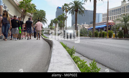 Las Vegas, USA - Circa 2017: Las Vegas blvd strip low angle day time exterior. People walk sidewalk past casino hotel entrance. Busy traffic drive by  Stock Photo