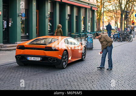 Orange Lamborghini Huracan LP 580-2 Spyder car released circa 2016 in Italy parked on the street causing a great interest among passers by. Stock Photo