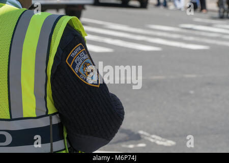 New York City, Circa 2017: NYPD Traffic police officer directing traffic during morning rush hour commute. Badge patch on sleeve of uniform Stock Photo