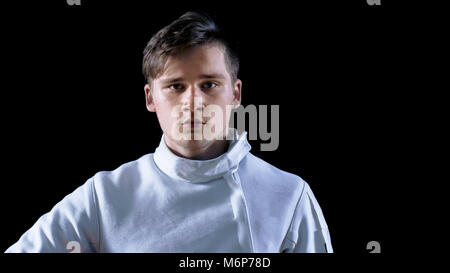 Portrait Shot of a Young Fencer Standing and Looking into Camera. Shot Isolated on Black Background. Stock Photo
