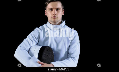 Portrait Shot of a Young Fencer Standing and Looking into Camera. Shot Isolated on Black Background. Stock Photo
