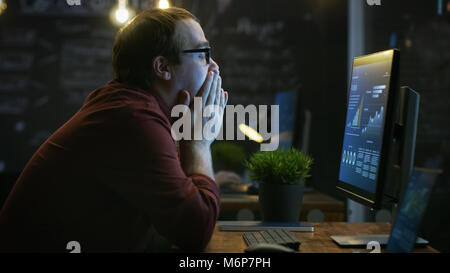 Stressed Financier Hits the Table with His Fist in Frustration and Covers His Face in Hands. He's Working on a Personal Computer with Statistics Stock Photo