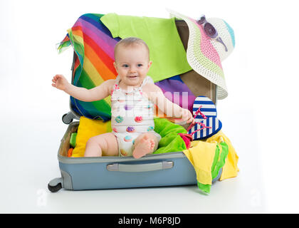 Baby toddler girl sitting in trunk with things for vacation travel Stock Photo