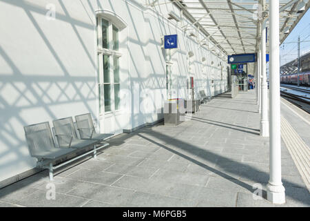 Modern train station wainting area on the platform with chairs and sign. Stock Photo