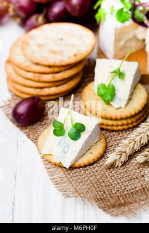 Crackers  and wedge of blue camembert cheese on sackcloth napkin Stock Photo