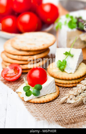 Crackers  and wedge of blue camembert cheese on sackcloth napkin Stock Photo