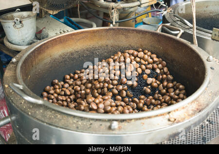 Roasting chestnuts on big pot. Agriculture products from Gimyong market in Hatyai Thailand Stock Photo