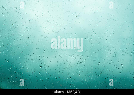 Rain drops on glass selective focus. Cloudy sky background Stock Photo