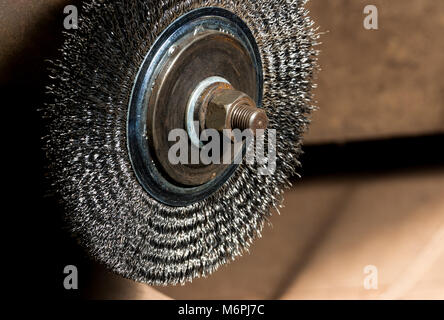 Vintage antique automotive machine shop electric grinder wire wheel on a rusty mandrel with nut Stock Photo