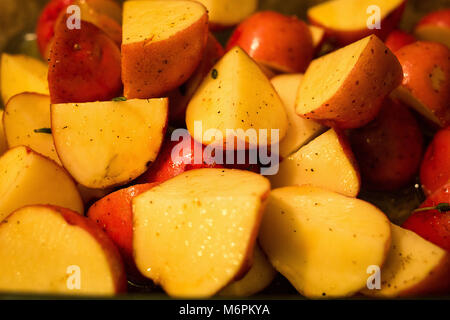 Cut potatoes ready to bake with spices macro Stock Photo