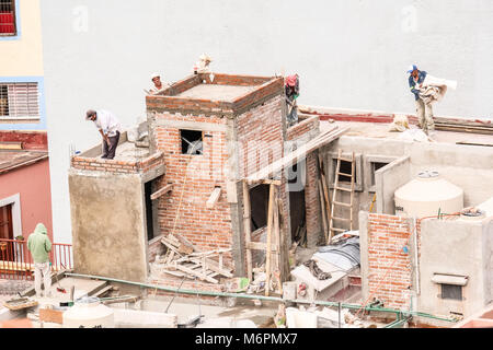 Mexican construction workers working on a half finished rooftop in Guanajuato, Mexico Stock Photo