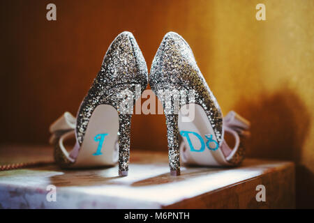 The bride's shoes with specific words 'I DO' on the bottom, luxury and feminine looks, glittering, sparkling, shiny Stock Photo