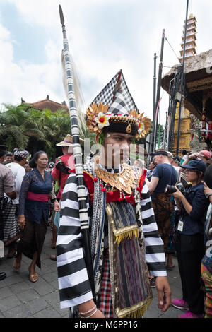 Balinese man in Ubud, Bali dressed in traditional clothes walks in procession for the cremation of Anak Agung Niang Agung from the royal household Stock Photo