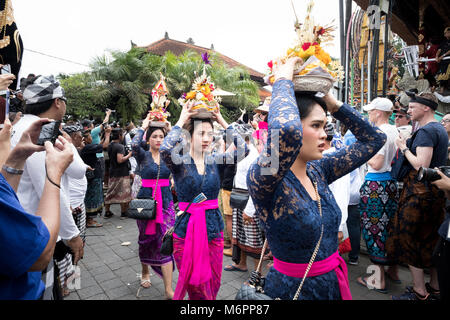 Balinese women in Ubud, Bali dressed in traditional clothes carry offerings for the cremation of Anak Agung Niang Agung from the royal household. Stock Photo