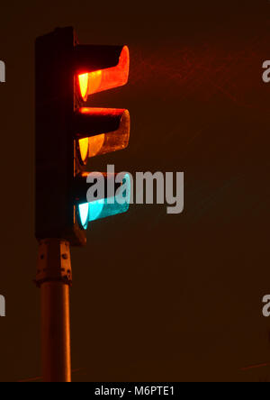 Traffic light seen in long time exposure  during a snow storm at night Stock Photo