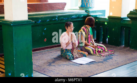 Yangon, Myanmar - February, 15, 2018: Buddhists at Shwedagon Pagoda Stock Photo