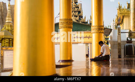 Yangon, Myanmar - February, 15, 2018: Buddhists at Shwedagon Pagoda Stock Photo