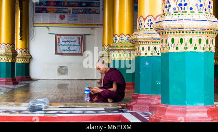 Yangon, Myanmar - February, 15, 2018: Buddhists at Shwedagon Pagoda Stock Photo