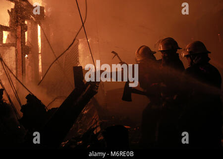 Quezon City, Philippines. 6th Mar, 2018. Firefighters extinguish fire at a slum in Quezon City, the Philippines, March 6, 2018. Credit: Rouelle Umali/Xinhua/Alamy Live News Stock Photo