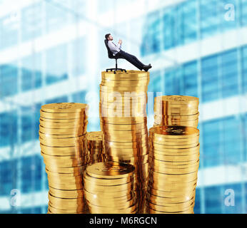 Successful businessman relaxing over piles of money. Concept of success and company growth Stock Photo