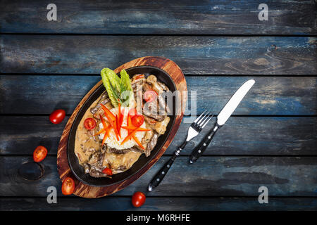 Lamb, bell pepper, celery, cauliflower stewed in cream sauce with rice garnish and cutlery on the wooden background, top view Stock Photo