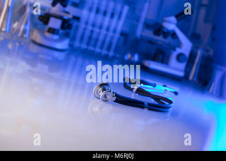 Stethoscope, microscope, laboratory background, lab glassware.  Blue background. Place for typography. Stock Photo