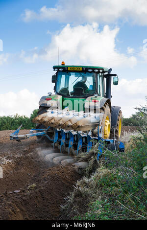 Ploughing with a modern John Deere tractor and reversible plough in North Norfok. Stock Photo