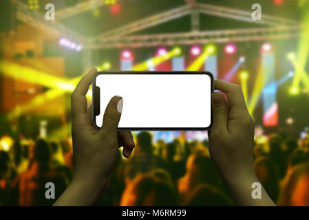 Modern smart phone in woman hand. Live music concert in background. Stock Photo