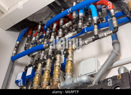 Gas and water pipes, joints and valves in a boiler room Stock Photo