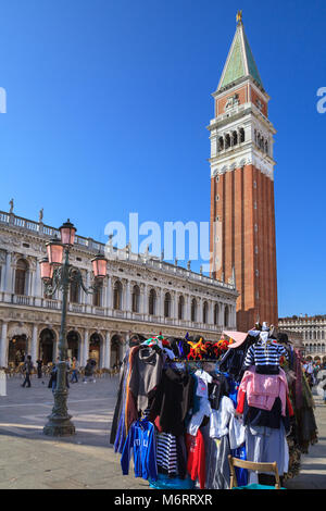 People and souvenir stall in St Mark's Square with the Campanile bell tower of St Mark's Basilica, Piazza San Marco, Venice, Italy Stock Photo